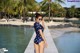 A woman in a polka dot swimsuit standing on a dock.