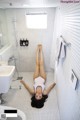 A woman laying on the floor in a bathroom.