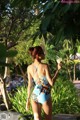 A woman in a blue swimsuit holding a drink.