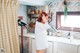 A woman standing in a kitchen next to a sink.