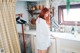 A woman standing in a kitchen next to a sink.