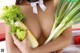 A woman holding a bunch of vegetables in her hands.