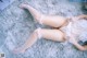 A woman laying on a fluffy white rug wearing fishnet stockings.