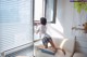 A woman sitting on a couch looking out a window.