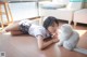 A woman laying on the floor next to a white cat.