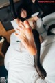 A woman laying on top of a bed with her feet up.