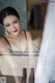 A woman in a black and white dress looking at herself in the mirror.