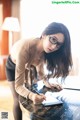 A woman in glasses writing on a piece of paper.