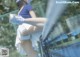 A woman in a blue shirt and white skirt playing tennis.