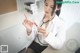 A woman in a white lab coat holding a syringe.