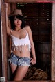 A woman in a cowboy hat is posing for a picture.