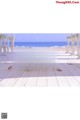 A woman in a white bikini laying on a wooden floor.