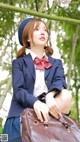 A woman in a school uniform holding a brown bag.