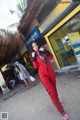 A woman in a red jumpsuit posing for a picture.