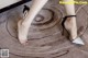 A close up of a woman's feet wearing a pair of black and silver shoes.