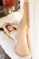 A woman laying on top of a bed in a white lingerie.