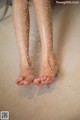 A woman's feet are covered in water. 