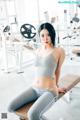 A woman sitting on a bench in a gym.