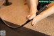 A woman is using a hair dryer to dry her feet.