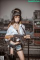 A woman in a military uniform holding a rifle.