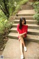 A woman sitting on the steps of a set of stairs.