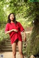 A woman in a red shirt is walking down some steps.