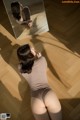 A woman laying on the floor in front of a mirror.