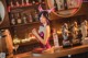 A woman in a bunny costume standing at a bar.