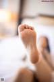 A close up of a person's foot on a bed.