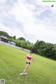 A woman in a bikini playing with a soccer ball.