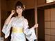 A woman in a blue and pink kimono posing for a picture.