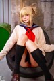 A woman in a sailor outfit sitting on a tire.