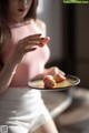 A woman holding a plate with strawberries on it.