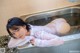 A woman laying in a sink in a bathroom.